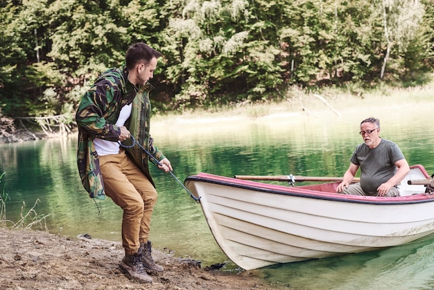 Foto gratuita hombres adultos varando un barco