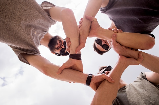 Hombres alegres unir manos juntos