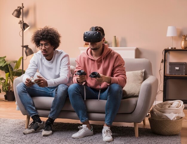 Foto gratuita hombres con auriculares virtuales y joystick