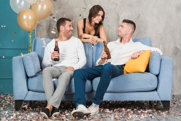 Hombres bebiendo cerveza y hablando con mujer