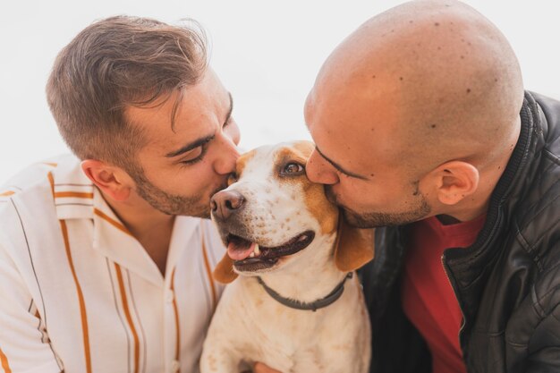 Hombres besando lindo perro