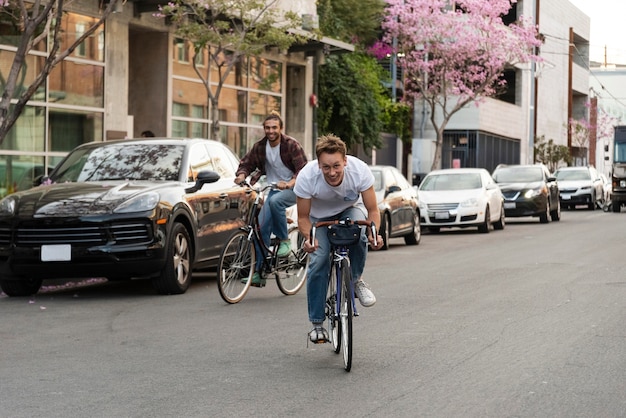 Hombres en bicicleta en la ciudad de tiro completo