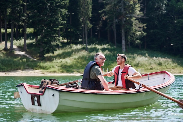 Foto gratuita hombres en un bote de remos durante el viaje de pesca