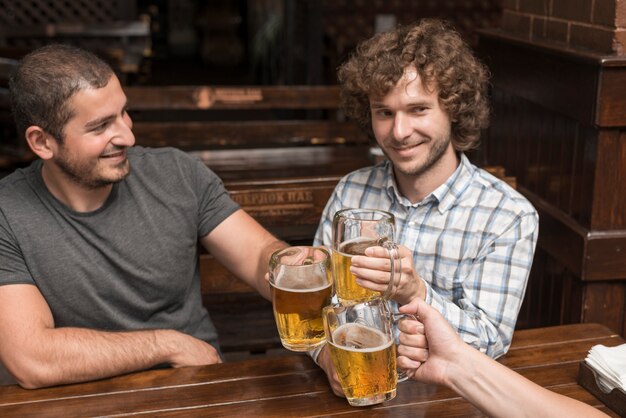 Hombres celebrando con un amigo en el bar