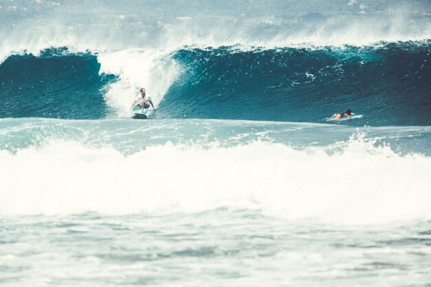 los hombres y las chicas están surfeando