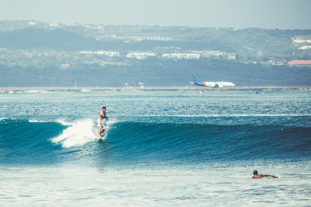 los hombres y las chicas están surfeando