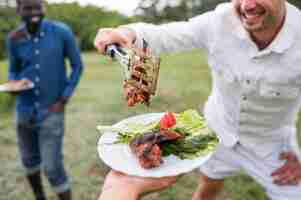 Foto gratuita hombres cocinando barbacoa al aire libre