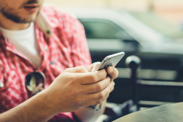 Los hombres comparten noticias, fotos y videos en el teléfono inteligente. Un hombre muestra a un amigo una aplicación en un teléfono móvil. Amigos con un teléfono inteligente, la tecnología.