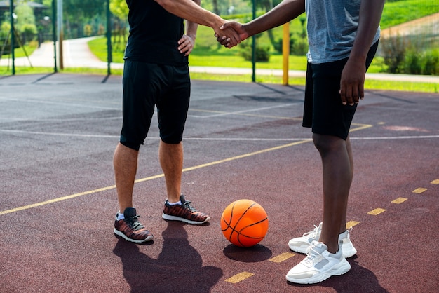 Hombres dándose la mano en la cancha de baloncesto