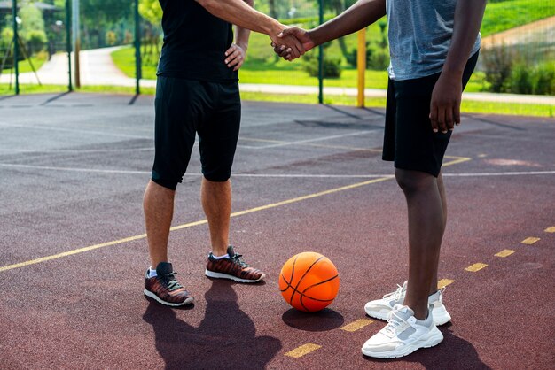 Hombres dándose la mano en la cancha de baloncesto