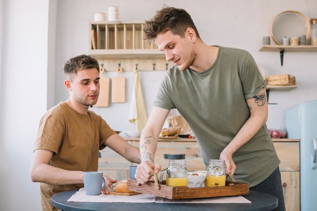 Hombres desayunando en mesa de comedor en cocina