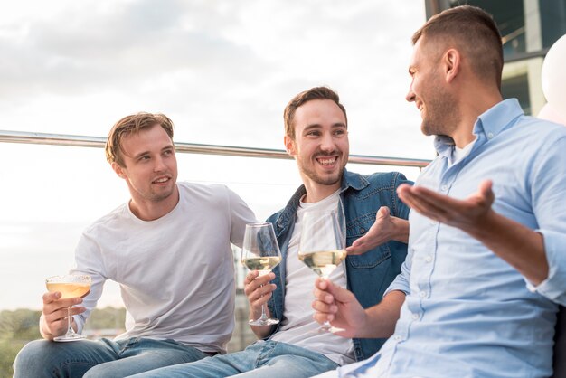 Hombres dialogando en una fiesta.