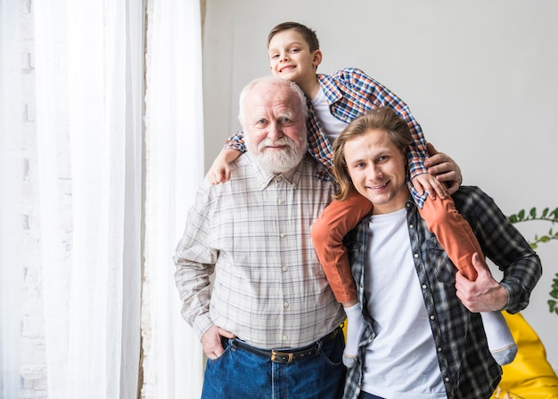 Hombres de diferentes generaciones de pie y abrazándose.