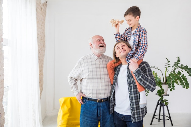 Hombres de diferentes generaciones de pie juntos sonriendo mientras juegan