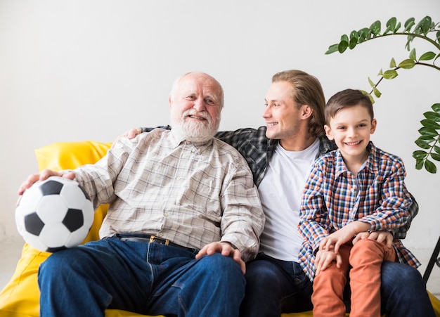 Hombres de diferentes generaciones sentados en el sofá.