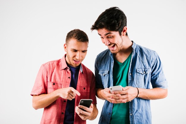 Hombres emocionados mirando smartphones