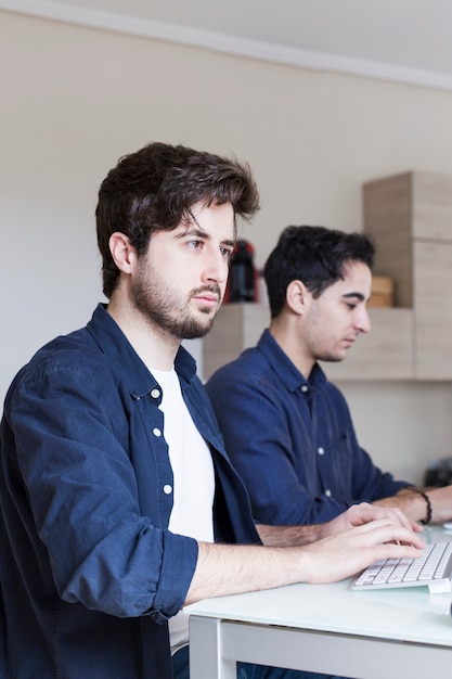 Hombres enfocados usando computadoras