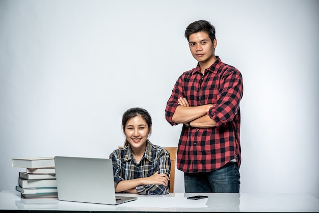 Los hombres enseñan a las mujeres cómo trabajar con computadoras portátiles en el trabajo.