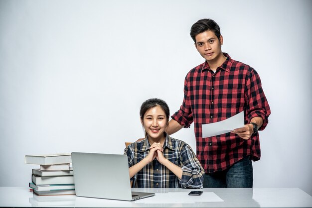 Los hombres enseñan a las mujeres cómo trabajar con computadoras portátiles en el trabajo.