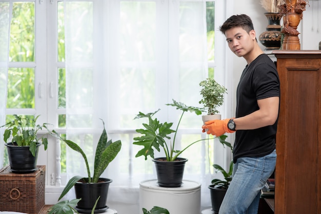 Hombres con guantes naranjas y plantando árboles en el interior.