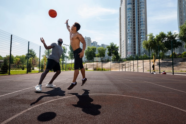 Hombres guapos lanzando pelota de baloncesto