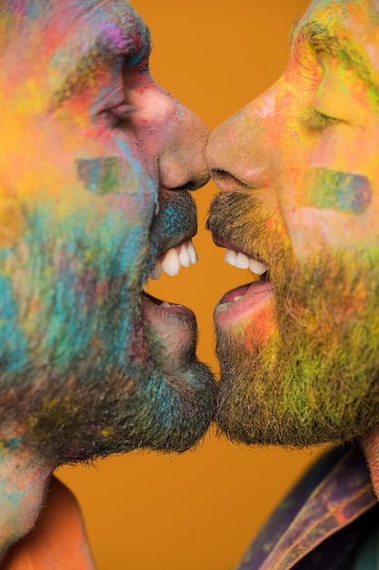 Hombres homosexuales felices cara a cara en pintura arco iris