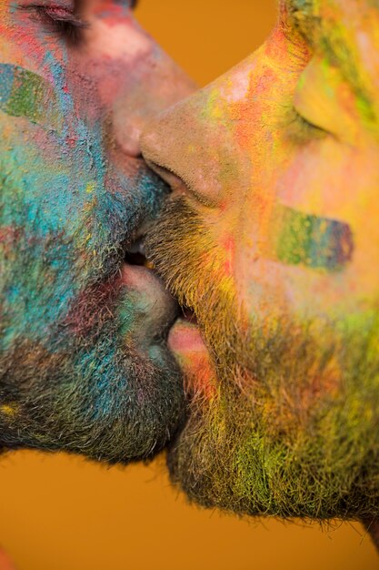 Hombres homosexuales pintados artísticamente besándose apasionadamente.