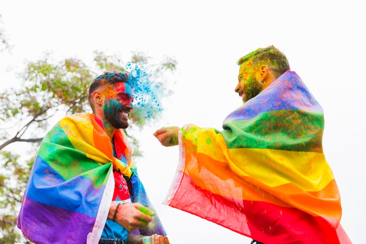 Foto gratuito hombres homosexuales rociándose el uno al otro con polvo de colores