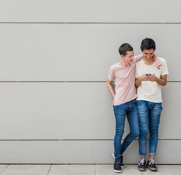 Hombres jóvenes juntos navegando por un teléfono