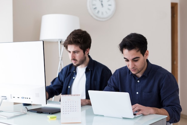 Foto gratuita hombres jóvenes que trabajan en la oficina