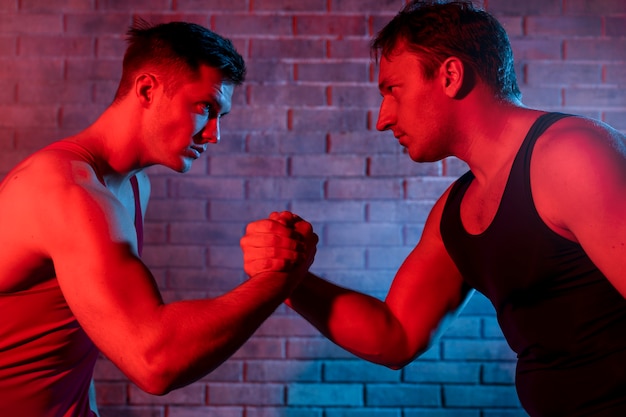 Hombres jóvenes en ropa deportiva luchando entre sí