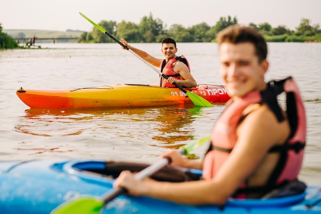 Hombres kayak con su amigo en el lago