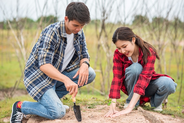 Los hombres y las mujeres ayudan a cultivar árboles.