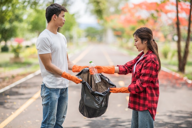 Hombres y mujeres se ayudan mutuamente para recolectar basura.