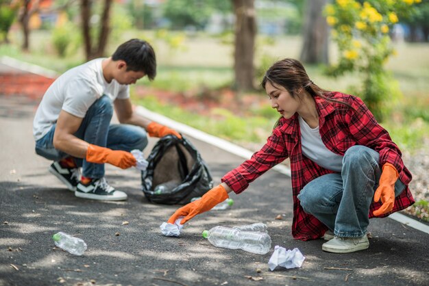 Hombres y mujeres se ayudan mutuamente para recolectar basura.