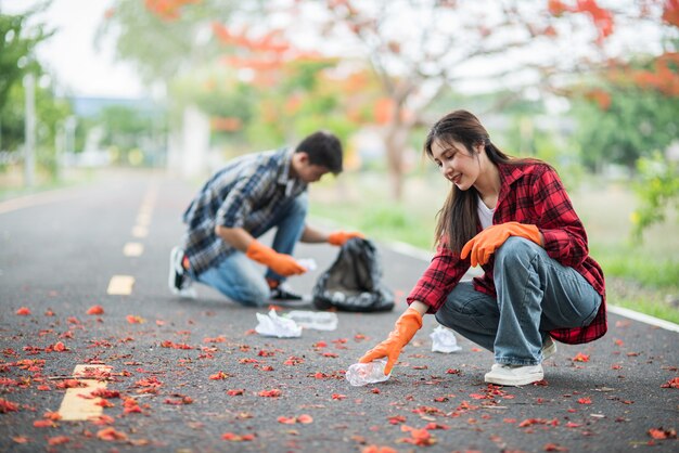 Hombres y mujeres se ayudan mutuamente para recolectar basura.