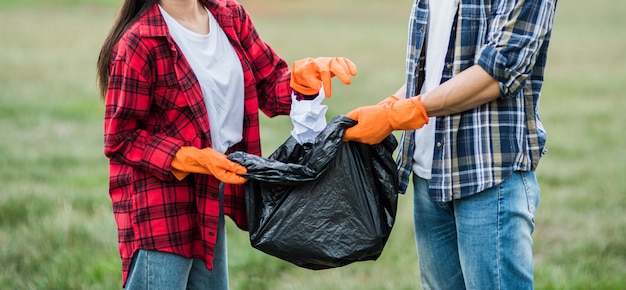 Hombres y mujeres se ayudan mutuamente para recolectar basura.