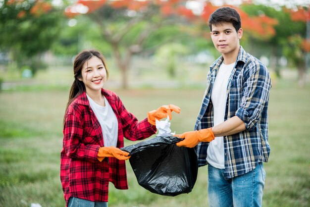 Hombres y mujeres se ayudan mutuamente para recolectar basura.