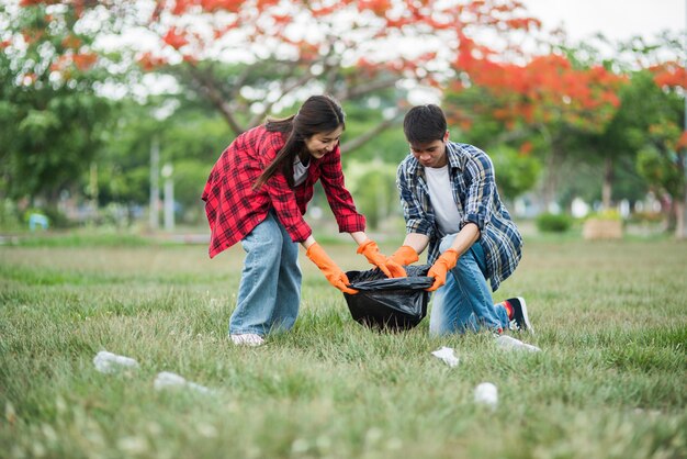 Hombres y mujeres se ayudan mutuamente para recolectar basura.