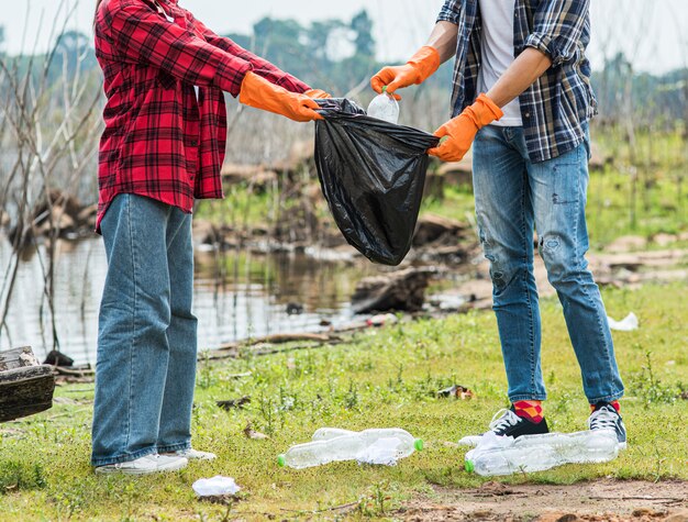 Hombres y mujeres se ayudan mutuamente para recolectar basura.