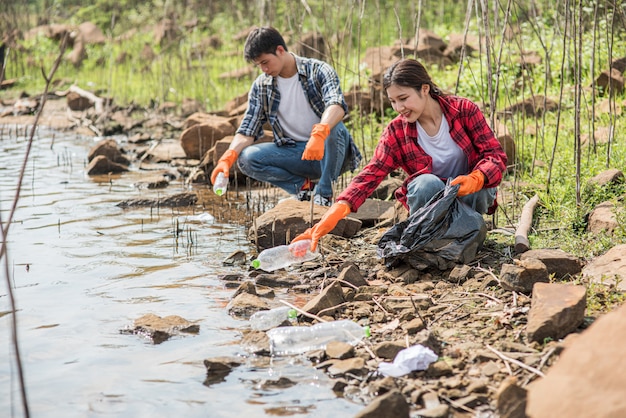 Hombres y mujeres se ayudan mutuamente para recolectar basura.