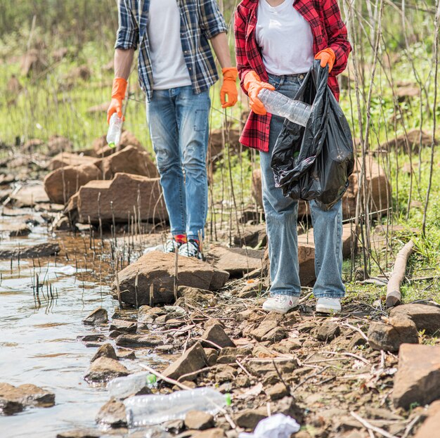 Hombres y mujeres se ayudan mutuamente para recolectar basura.