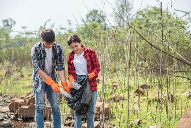 Hombres y mujeres se ayudan mutuamente para recolectar basura.