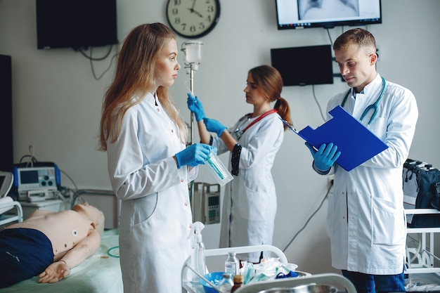 Foto gratuita hombres y mujeres con batas de hospital sostienen equipos médicos en sus manos. la enfermera conecta el goteo.