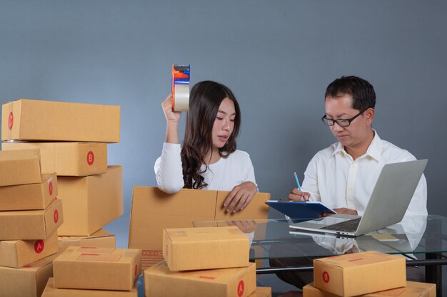 Hombres y mujeres están ayudando a empacar las cajas.