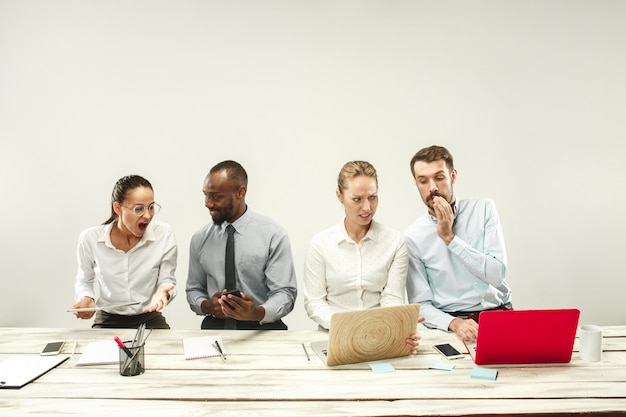 Hombres y mujeres jóvenes sentados en la oficina y trabajando en computadoras portátiles. Concepto de emociones