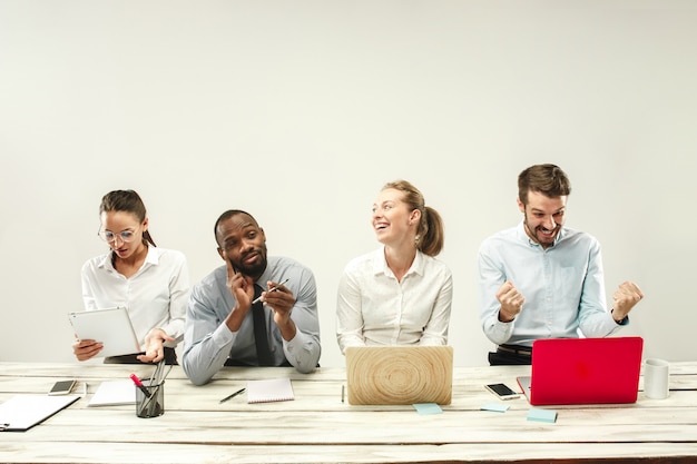 Hombres y mujeres jóvenes sentados en la oficina y trabajando en computadoras portátiles. Concepto de emociones