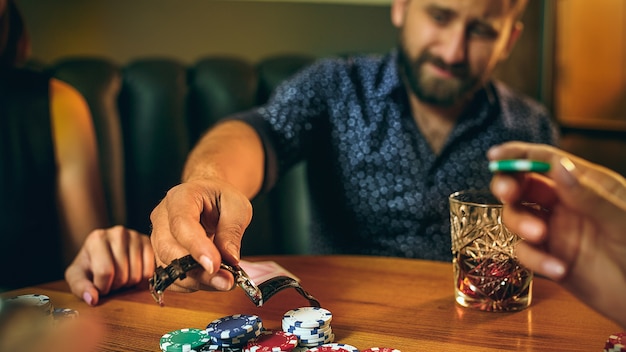 Foto gratuita hombres y mujeres jugando al juego de cartas. poker, entretenimiento nocturno y concepto de emoción.