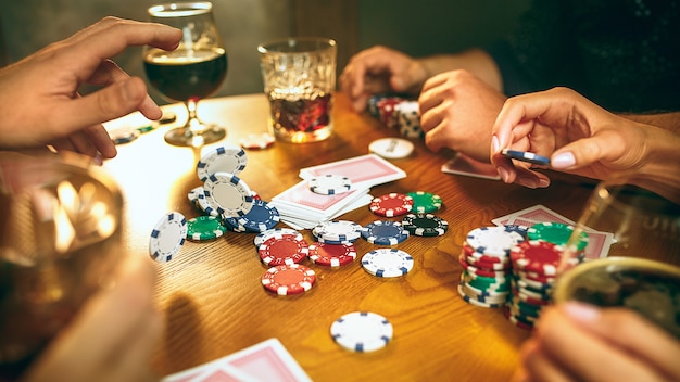 Hombres y mujeres jugando al juego de cartas. Poker, entretenimiento nocturno y concepto de emoción.