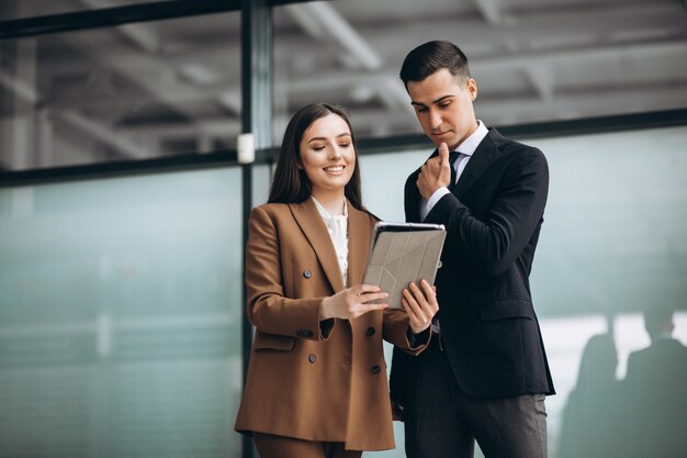 Hombres y mujeres de negocios trabajando en tableta en la oficina